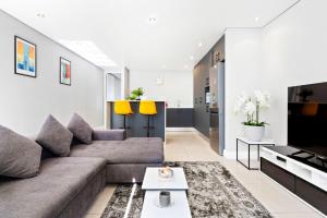 a living room with a couch and a table at Eden on the Bay 190 by Host Agents in Cape Town