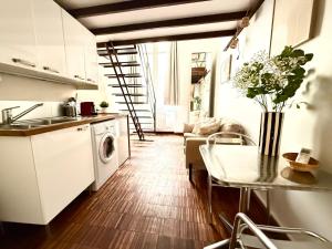 a kitchen and living room with a table and a laundry machine at La Maison de Sebea in Bordeaux