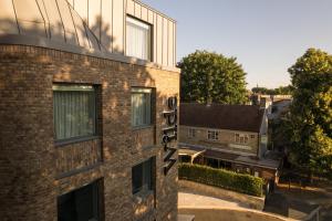 un edificio di mattoni con un cartello sul lato di Wilde Aparthotels Cambridge City Centre a Cambridge