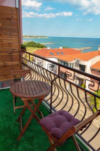 a balcony with a table and chairs on the grass at Apartment Sea View in Burgas City