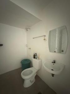 a white bathroom with a toilet and a sink at Villa Ebarle Diving Resort in Mabini +32 photos