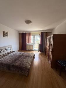 a bedroom with a bed and a large window at ApartCluj4rent in Cluj-Napoca