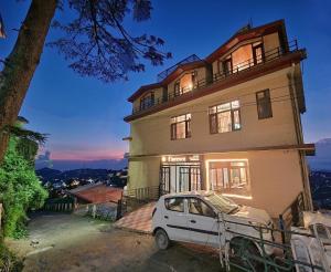 a white car parked in front of a house at Florence B&B Near Mall Road - Amazing Valley View in Shimla