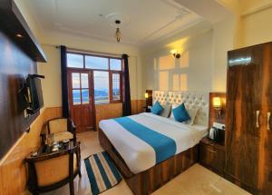 a bedroom with a large bed and a window at Florence B&B Near Mall Road - Amazing Valley View in Shimla