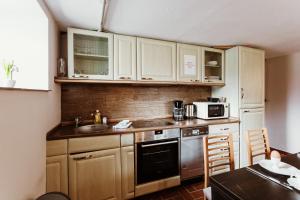 a kitchen with white cabinets and a sink and a stove at Teufels - Zuflucht in Thale +11 photos
