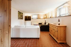 a living room with a white couch and a kitchen at Teufels - Zuflucht in Thale