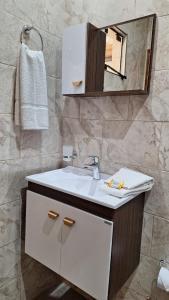 une salle de bain avec un lavabo blanc et un miroir dans l'établissement Apart puesta del sol Iguazú, à Puerto Iguazú