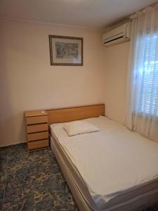 a small bedroom with a bed and a window at Bunaglows Panoramic Beach Village in Balchik
