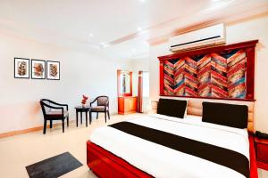 a bedroom with a bed and a table and chairs at Collection O Anantapur Railway Station in Anantapur