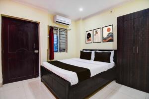 a bedroom with a large bed with a black door at Hotel O Zoological Park Nandankanan Resort in Bārang