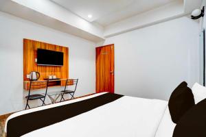 a bedroom with a bed and a desk with a television at Collection O Kargil Complex Saarthi Inn in Agra +17 photos