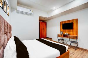 a bedroom with a bed and a desk and a television at Collection O Kargil Complex Saarthi Inn in Agra