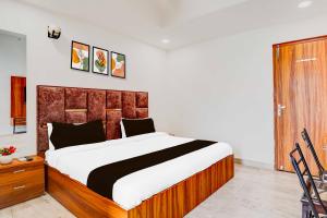 a bedroom with a large bed with a wooden headboard at Collection O Kargil Complex Saarthi Inn in Agra