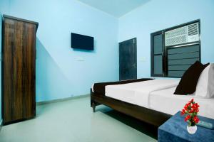 a bedroom with a large bed and a tv at Hotel O Nayagaon Vikas Nagar in Chandīgarh