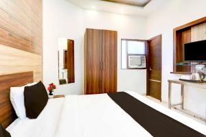 a bedroom with a white bed and a television at Collection O Chandigarh Highway Near Prabhat Road in Chandīgarh +22 photos