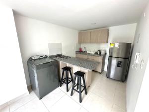 a small kitchen with a counter and a refrigerator at Hermoso apto central Urban in Manizales