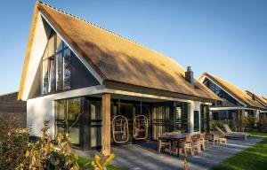 a house with a thatched roof and a patio at H-1 Buytenveldt in De Cocksdorp