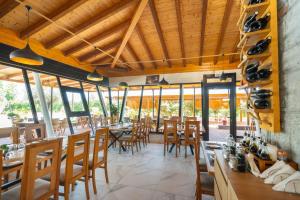a restaurant with wooden ceilings and wooden tables and chairs at Natyra e Ishullit -Resort- in Ishull-Shëngjini