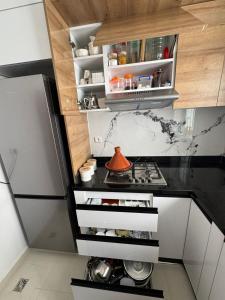 a small kitchen with a stove and cabinets at Afalux Brand chic in Agadir +29 photos