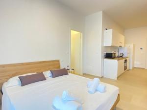 a bedroom with a white bed with towels on it at Suite Emilia 2 in Bologna