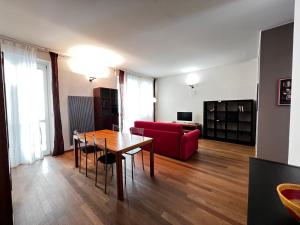 a living room with a table and a red couch at Mole Antonelliana - Box Auto Gratuito by RD Domus in Turin
