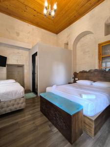a bedroom with two beds and a wooden ceiling at yıldız saray konuk evi in Sanlıurfa