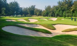 um grupo de golfistas jogando em um campo de golfe em Clover Greens Golf Course and Resort em Sarjāpur