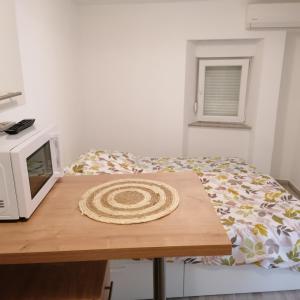 a small bedroom with a bed and a microwave at Pool House Viro In Center Novalja in Novalja