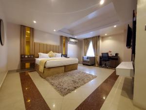 拉各斯BWC Hotel的一间卧室，配有一张床、一张书桌和一台电视