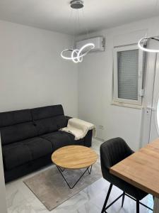 a living room with a black couch and a table at Apartman GUŠI in Knin