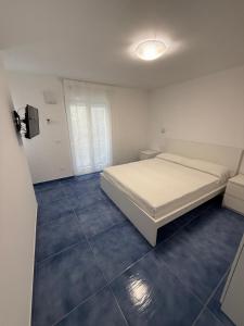 Un dormitorio blanco con una cama y una ventana. en Casa Buono Holidays, en Isquia