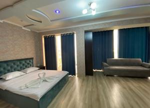a bedroom with a large bed and a couch at Milano Garden Plaza Samarkand in Samarkand +5 photos