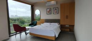 a bedroom with a bed and a large window at PubliQ Luxury Stays in Hyderabad