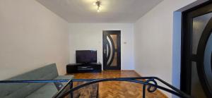 a room with a staircase with a tv and a couch at Gollums House in Sighişoara