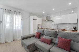 sala de estar con sofá gris y almohadas rojas en Sun Garden, en Adeje