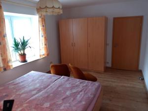 a bedroom with a table and chairs and a window at Ferienwohnung Kälberstall in Reinhardtsdorf