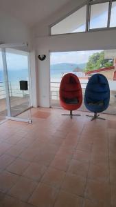 two chairs in a room with a view of the ocean at Villa Ebarle Diving Resort in Mabini