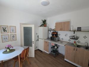 a kitchen with a table and a white refrigerator at Urban Oasis in Târgu-Mureş