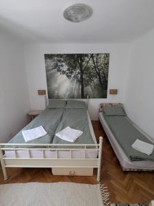 a bedroom with two beds and a painting on the wall at Urban Oasis in Târgu-Mureş