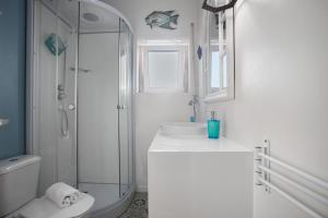 a white bathroom with a shower and a sink at Praia Azul Beach and Sun in Silveira +28 photos