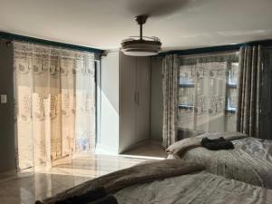a bedroom with two beds and a window with curtains at Crompton Studio Apartment 786 in Durban