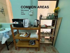 a kitchen with a microwave on a shelf with a counter at Choltara home in Hat Yai