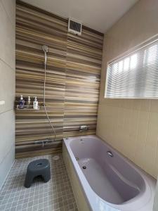 a bath tub in a bathroom with a window at Locanda Laltra Cucina in Yokosuka