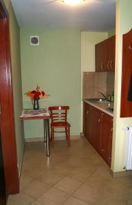 a kitchen with a table with a vase of flowers on it at Ośrodek Wypoczynkowy "Przy Lesie" in Karpacz +7 photos