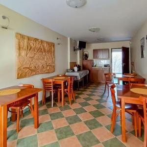 a dining room with tables and chairs and a kitchen at Ośrodek Wypoczynkowy "Przy Lesie" in Karpacz