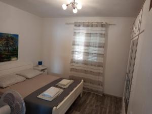 a small bedroom with a bed and a window at Sea View Apartment Sunrise Poljica & Blue Lagoon Rent A Boat in Poljica