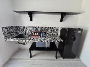a kitchen counter with a sink and a refrigerator at Comoda Suite Privada in Cancún