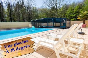 a swimming pool with two lawn chairs and a sign that reads the passive at Logement insolite "Bubble jungle" in Saint-Évarzec
