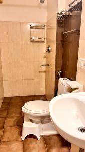a bathroom with a toilet and a sink at GoArize by Rootsvilla Vagator in Anjuna +26 photos