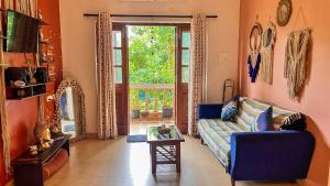 Una sala de estar con un sofá azul y una mesa. en Dreamy Boho Haven Vagator, en Anjuna